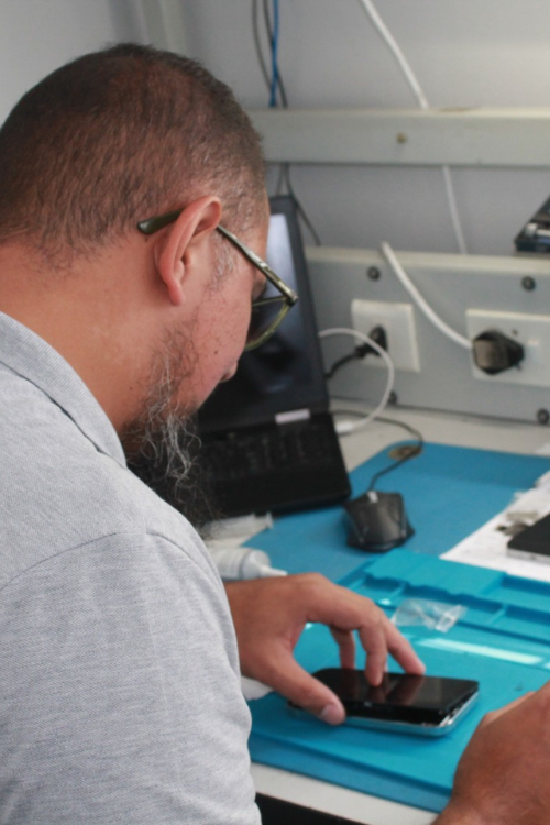 Rizaan, TT3 Repairs technician, repairing a smartphone and laptop at the service workstation in Port Elizabeth.
