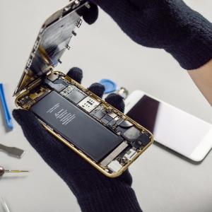 Technician repairing a smartphone motherboard using professional diagnostic and soldering equipment at TT3 Repairs.