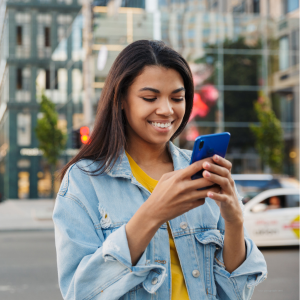 Happy TT3 Repairs customer smiling while using a smartphone after a successful device repair